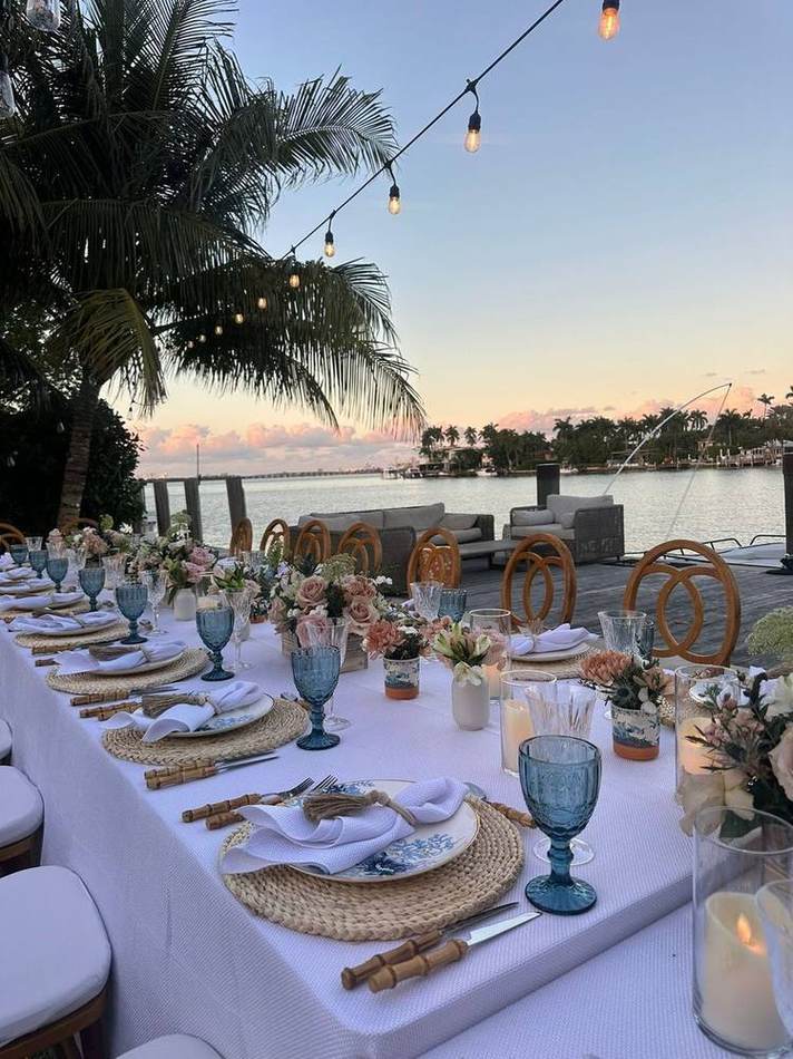 Long table, palms, sunset over the water. Chef Tasos Luxury Dining, Miami