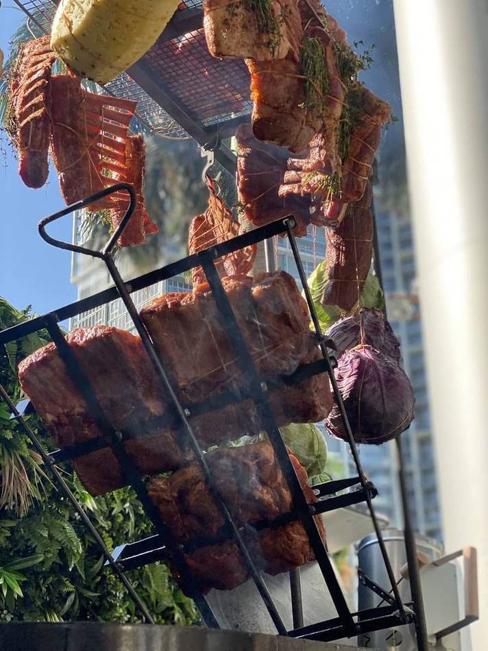 Ribs hanging over fire. Chef Tasos Luxury Dining, Miami