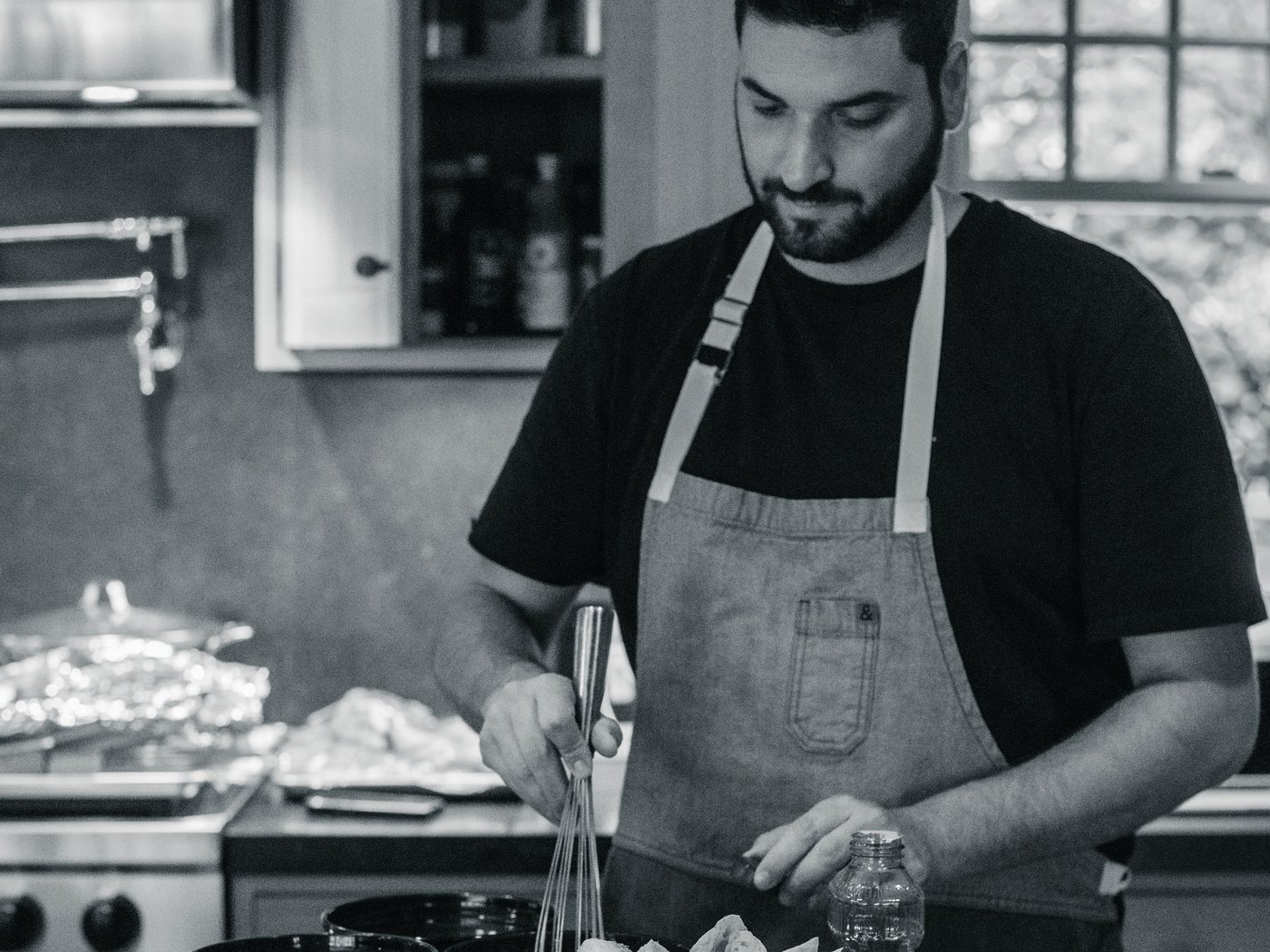 A chef in an apron preparing dinner in a home kitchen
